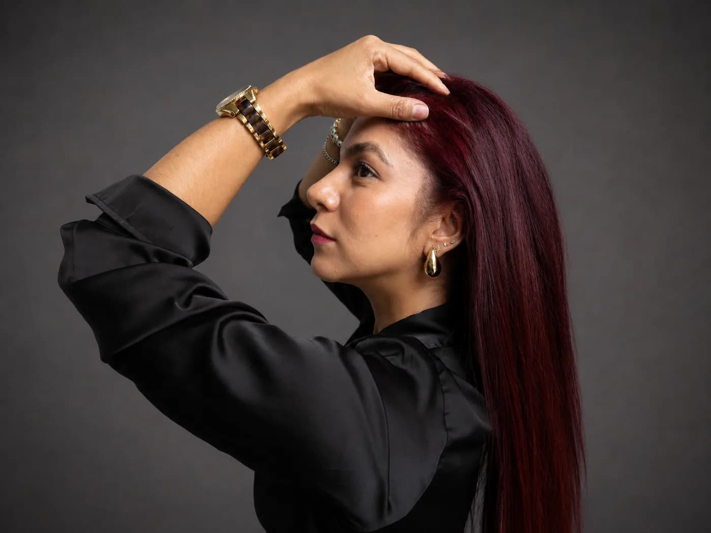 Perfil de una mujer de cabello rojo con la mano apoyada en la frente