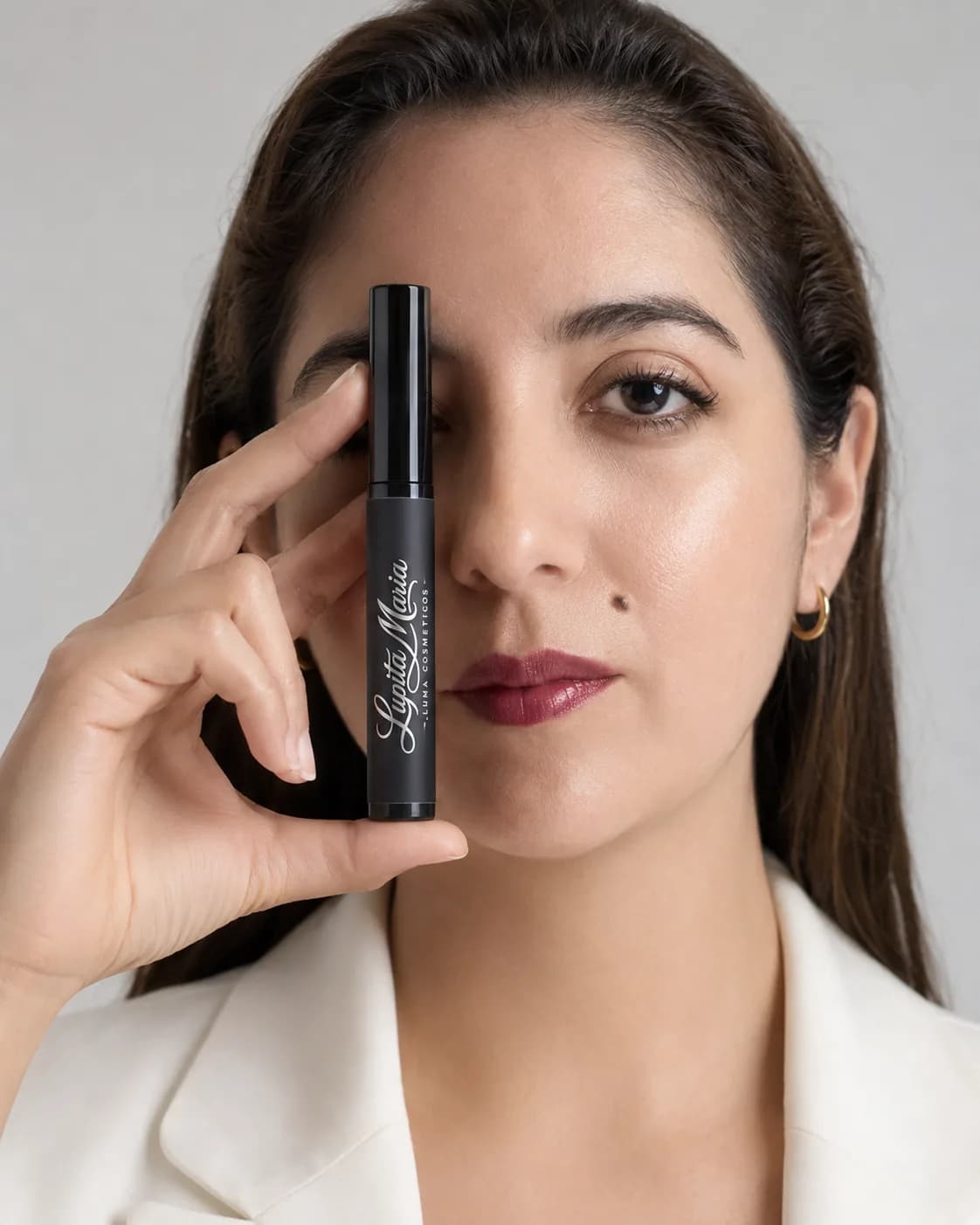 Mujer sosteniendo la máscara de pestañas Lupita María frente a uno de sus ojos